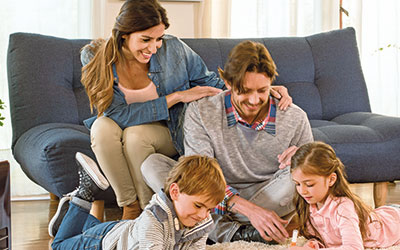 Foto de familia reunida en el living con dos padres y dos hijos